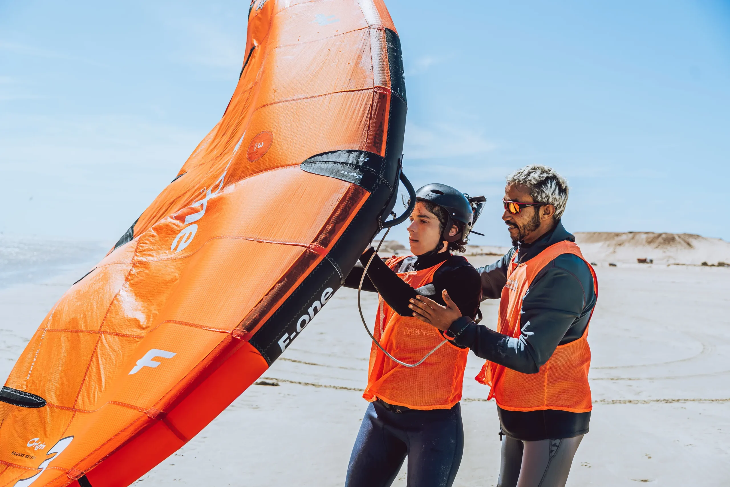 Cours de wingfoil à Dakhla avec moniteur ajustant la posture et la position de l’aile pour un élève