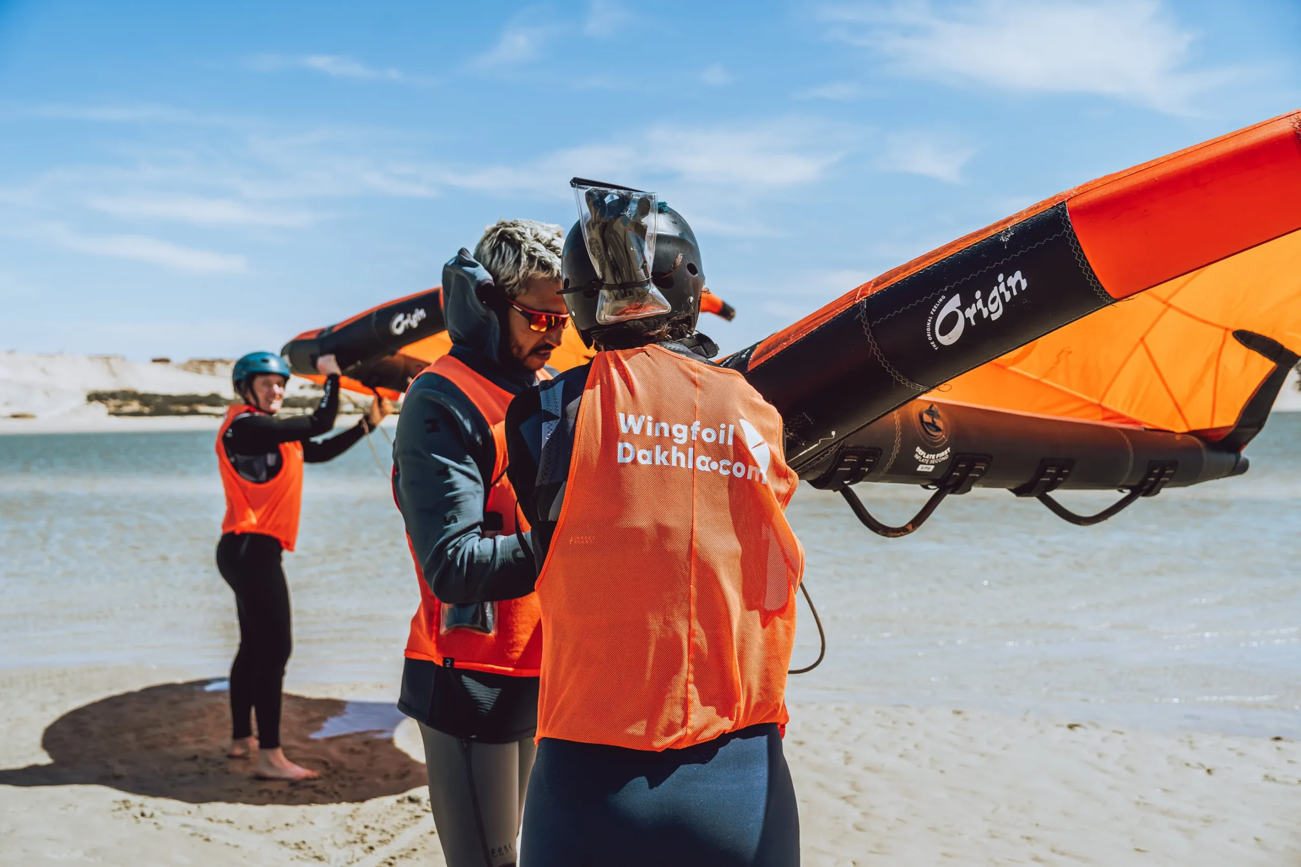 Cours de wingfoil à Dakhla avec casque radio – moniteur donnant des instructions personnalisées sur la plage