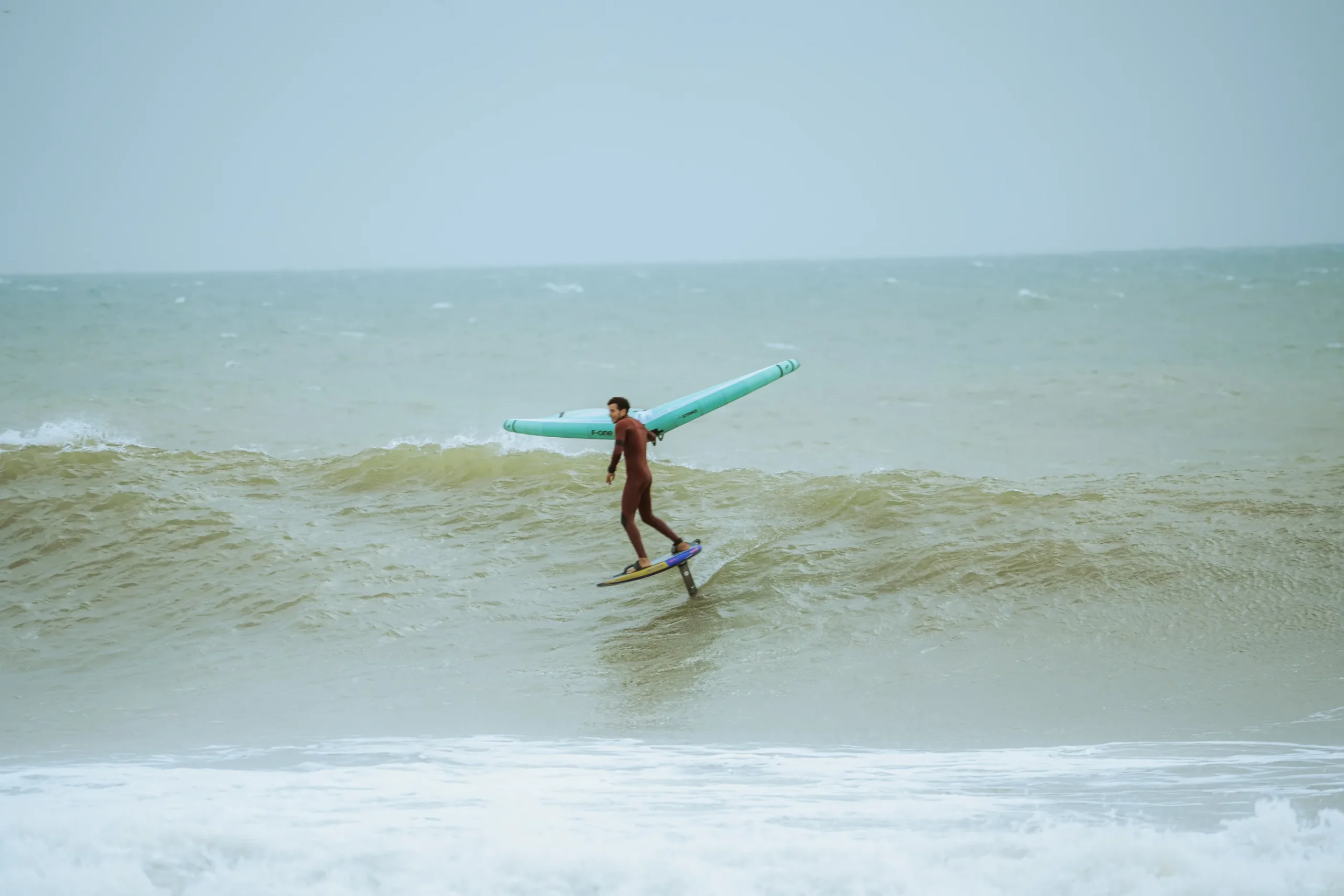 Zouhair Mouyh en wingfoil sur une vague à Oum Lbouir à Dakhla – spot idéal pour débuter en vagues