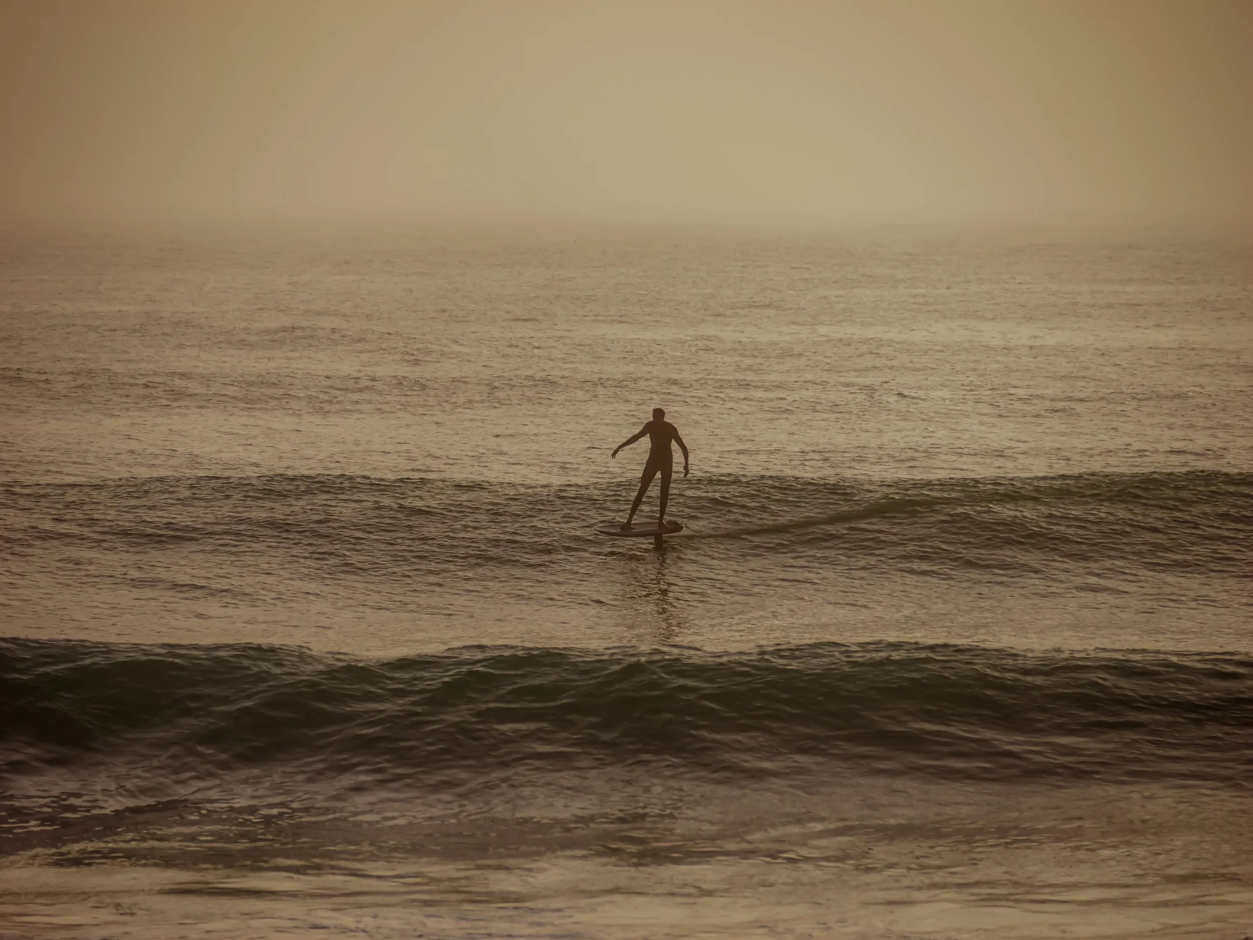 Rider en surf foil au spot Oum Lbouir à Dakhla au coucher du soleil – Wingfoil Dakhla